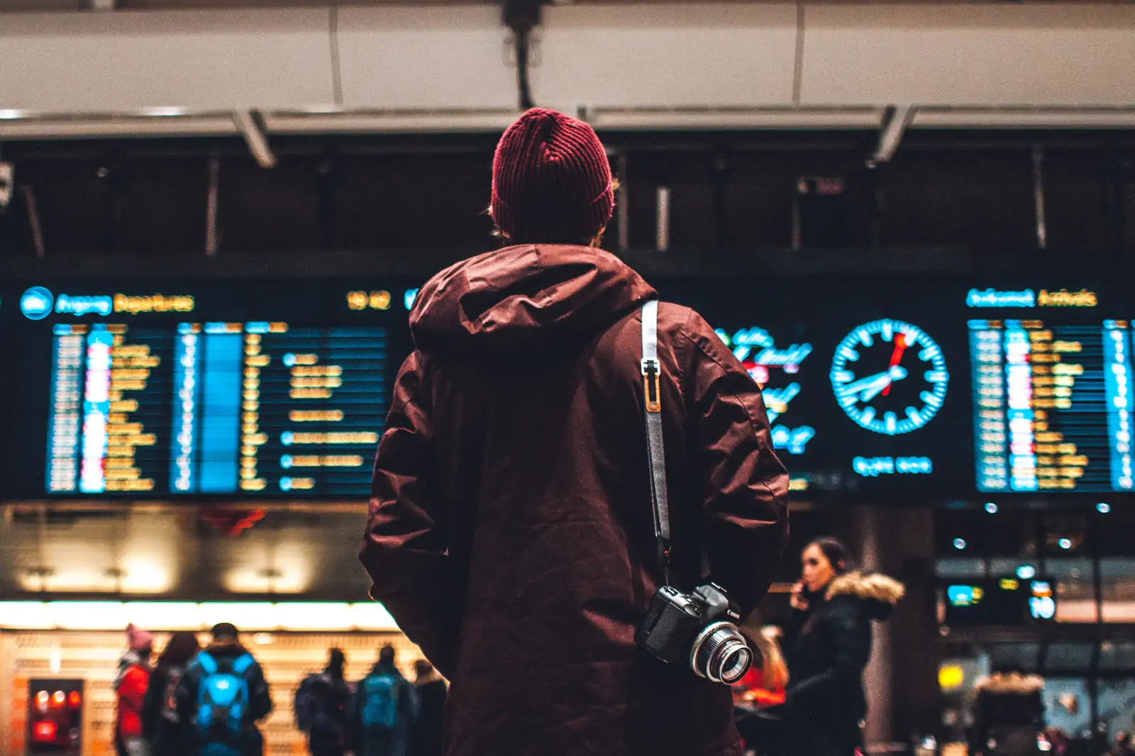 Viajante olhando o painel de partidas do aeroporto
